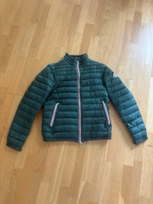 Mörkgrön pufferjacka från Moncler - Snygg mörkgrön Moncler Daniel Gribrutto. Storlek 1, som motsvara S/M. Nästan aldrig använd och äkta såklart. Skriv om ni är intresserade:)