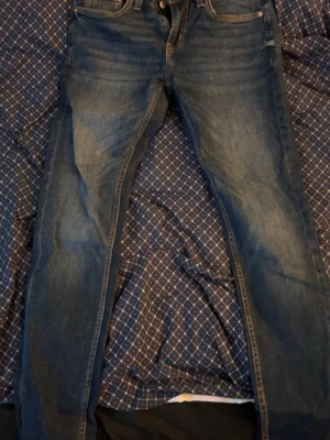 Mörkblå raka jeans - Snygga mörkblå jeans med klassisk femficksdesign och raka ben. Jeansen har en enkel look utan slitningar och är tillverkade i ett mjukt denimtyg. Perfekta för en stilren och avslappnad outfit.