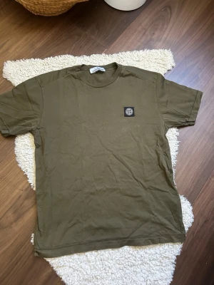 Olivgrön Stone Island t-shirt M - Säljer min stone island tshirt i storlek medium. Säljer eftersom jag inte använder den längre och den är köpt på NK för ca 2,5 år sedan. Nypriset var 1900kr. Priset är inte hugget i sten om man kan erbjuda en snabb affär!