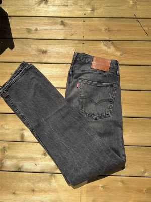Levi's svarta raka jeans - Säljer ett par klassiska svarta jeans från Levi's med rak passform och femficksdesign. Jeansen har en snygg vintage-look och är tillverkade i slitstarkt denim med läderpatch bak. Perfekt för dig som gillar tidlös stil. Storlek är W 31 L 32 pris kan diskuteras 