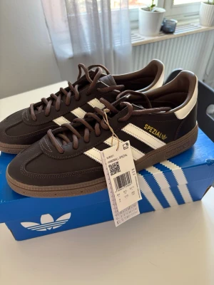 Adidas Handball Spezial bruna sneakers - Mörkbruna Adidas Handball Spezial sneakers. Helt oanvända med prislapp och originalförpackning. Storlek 42⅔. Orginalpris ≈ 1250