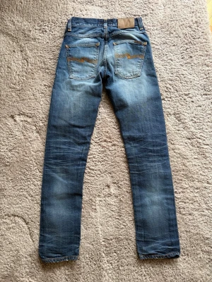 Nudie Jeans Grim Tim Selvage Simon Replica - Modell: Grim Tim Simon Replica 🪬  Färg: Blå/Mörkblå 🪬  Storlek: W27 L30 🪬  Mått: W34cm L98cm Benöppning 15cm 🪬  Skriv vid minsta fundering! 🪬