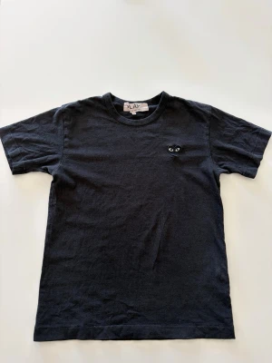 Comme Des Garçons T-Shirt - En svart snygg T-shirt från Comme Des Garçons. Skick 8/10 och storlek S. Perfekt till sommaren! Pris kan diskuteras!