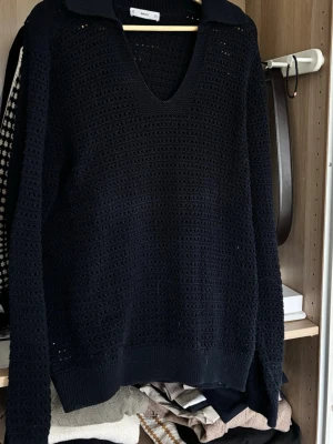 Marinblå stickad tröja med krage från MNG - Marinblå  stickad tröja från MNG med djup v-ringning och klassisk krage. Tröjan har ett snyggt hålmönster och långa ärmar. Perfekt att styla med jeans eller kjol för en trendig look.