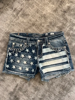 Miss me shorts - Miss me shorts med stjärnor och ränder på framsidan, samt snygga detaljer på baksidan, även miss me märket bak och ett märke på knappen, samt små fina detaljer som pärlor och gnistrande stenar. De är i storlek 28, motsvarar storlek 36/S!