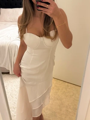 Vit klänning - Säljer en vit figurnära klänning från Boohoo i storlek 36 med mesh-volanger nertill. Aldrig använt, endast provad. Säljs då den var för tight upptill på mig☺️