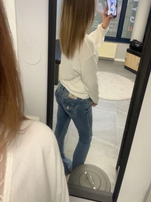 True religion jeans vingar  - Märke: True religion  Storlek: 25  Färg: Blå, vit  Utseende: Modell Joey med vingar 🪽   Jätte snygga, kommer inte till användning men snygga detaljer. 🪽 priset är diskuterbart men kommer inte gå ner för mycket 