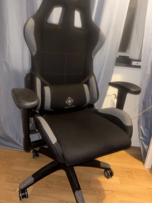  gamingstol från Deltaco - Säljer en svart gamingstol från Deltaco Gaming med grå detaljer. Stolen har justerbara armstöd, hjul och en ergonomisk design med hög rygg och stöd för svank. Klädseln är i slitstarkt tyg och stolen har sportig racingstil. Finns slitage som ni ser på bilderna , påverkar dock inte bekvämligheten och hjulen är i full funktion.
