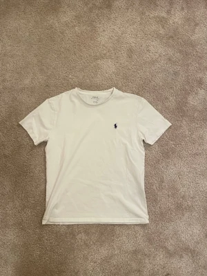 Vit t-shirt från Polo Ralph Lauren - Säljer en jätte fin vit t-shirt från Polo Ralph Lauren. . Fick i julas men den är för stor så har bara använt den hemma, så nästan helt ny. Stoleken är runt xs-s🙏🏻 skriv om funderingar eller prisförslag. 