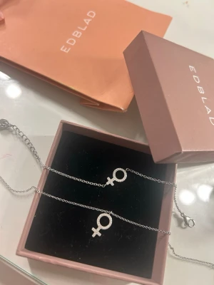Edblad halsband och armband - Säljer ett armband och ett halsbandet från Edblad från samma kollektion. Armbandet och halsbandet har en enkel kedja och symbolen är dekorerad med små gnistrande stenar för extra bling. Man kan köpa båda för 300 kr eller ett för 150 kr.