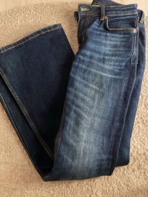 Mörkblå bootcut jeans med slitningar - Säljer ett par mörkblå bootcut jeans. I storlek 26/32