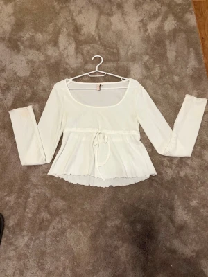 Vit topp från nelly  - Supersöt och skön topp från Nelly! Kommer inte till användning och är använd ca 2 gånger.  Bara att höra av sig vid fler bilder eller andra frågor❣️