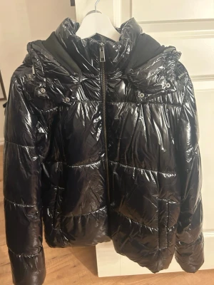 Svart glansig pufferjacka - Säljer en svart, glansig jacka från Nelly💗
