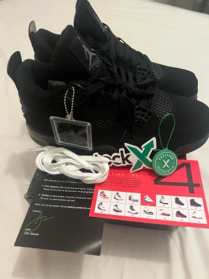 Jordan 4 black cat - Snygga helsvarta Air Jordan 4 Retro sneakers med klassisk siluett, Jumpman-logga på plösen och meshdetaljer på sidorna. Skorna har ovandel i mocka och läder, samt robust gummisula. Levereras med extra vita skosnören och originaldetaljer.