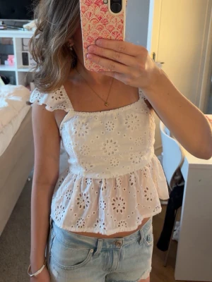 Vit blus -  Säljer denna Vita sommar blus från H&M med knyte i ryggen och volanger storlek S men lassar xs också