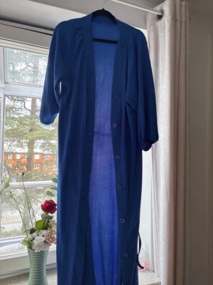 Blå klänning - Vardaglig, använt 1 gång. Inga fel eller fläckar. Är 160 cm och den går ända ner till lite ovanför hälarna på mig. Kan användas som klänning eller kofta