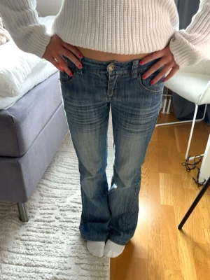 Blå bootcut jeans - Säljer ett par lågmidjade bootcut jeans med tvättade detaljer. Säljer de eftersom de tyvärr är för små för mig! Storlek S🥰