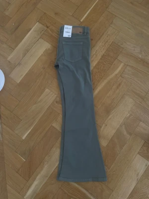 Gröna flare jeans från 157 - Snygga gröna flare jeans från 157 i modellen Blaze Star. Jeansen har klassisk femficksdesign, normal passform upptill och utsvängda ben. Perfekta för dig som vill ha en trendig och bekväm look. Materialet känns mjukt och slitstarkt.