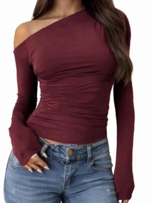 Vinröd oneshoulder topp - Snygg vinröd topp med oneshoulder-design och långa ärmar. Toppen har en tight passform och är tillverkad i ett mjukt, stretchigt material som sitter skönt på kroppen. Perfekt för dig som vill ha en trendig och stilren look.