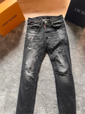 Dsq2 jeans svart - Dsq2 svarta jeans köpta i Tyskland. Jag säljer dem för att jag rensar garderoben. Ask i bilden följer ej med. De är i gott skick knappast använda. Passar på människor mellan 165-183cm