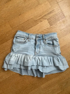 Ljusblå jeanskjol med volang - Jättefin jeanskjol med volang. Den är gjord av ett par omsydda jeans från Gina tricot.