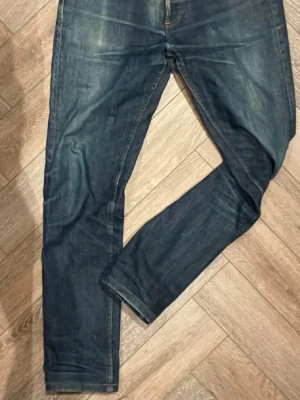 APC Jeans - Säljer ett par mörkblå slim fit jeans med klassisk femficksdesign och lätt slitna detaljer. Jeansen har raka ben och normal midja. Perfekta till en avslappnad streetwear-look. Materialet är denim i bomull.