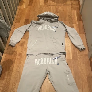 Grå hoodie från Hoodrich - ‼️‼️Priset kan diskuteras ‼️‼️Säljer en stilren grå hoodie från Hoodrich med stor logga på framsidan. Tröjan har en praktisk känguruficka och ribbade muddar vid ärmslut. Perfekt för en avslappnad stil.