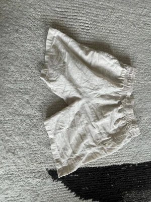 Beiga linne-shorts med resårmidja - Säljer ett par ljusa beiga shorts i linne med avslappnad passform och elastisk midja. Perfekta för varma sommardagar och riktigt sköna att bära. Klassisk och enkel design utan extra detaljer.