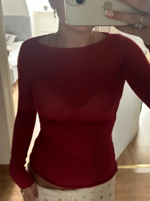 Röd långärmad topp i stretchigt tyg från Intimissimi❤️ - Snygg röd långärmad topp med tight passform och rund halsringning. Tillverkad i ett stretchigt och mjukt material som sitter skönt mot kroppen. Tröjan har ett litet hål på undersidan av handen (se bild 5) som inte syns när man har på sig den💓