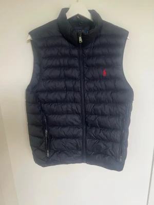 Polo Ralph Lauren väst - Tja, säljer nu denna väst från Polo Ralph lauren. Västen är endast använd några fåtal gånger dvs den är i ny skick. Västen är i storlek S men passar både mindre och större eftersom man själv kan ändra hur stort/tajt den ska sitta. Hör av er vid fler frågor😃