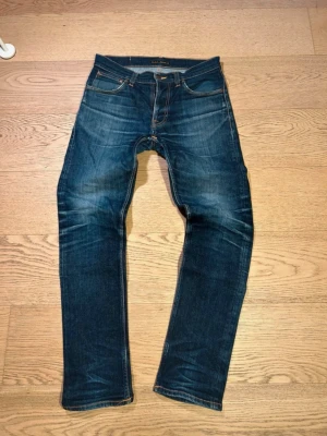 Nudie Jeans - Grim Tim - Säljer ett år riktigt snygga Nudie Jeans i storleken W32 L32 👖. Jeansen har använts i ungefär 1 år och med tiden fått riktigt snygga fades, perfekta för sommaren! ⛱️! Lagning vid skrevet har blivit proffesionellt lagad av Nudie Jeans butiken i Göteborg! Hör av er ifall ni har några frågor! ⭐️⚜️