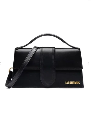 Svart Jacquemus handväska i läder - Snygg svart handväska från Jacquemus i slätt läder med guldfärgad logga på framsidan. Väskan har både topphandtag och avtagbar axelrem, samt en stilren rektangulär form. Perfekt accessoar för att lyfta din outfit.Höjd: 14 cm | Längd: 24 cm | Bredd: 7 cm | aldrig kommit till användning, därmed säljs.