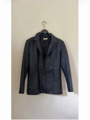 Vintage caballero dorado skinnkavaj - Stilren svart fakeskinnjacka med två knappar framtill och klassisk krage. Köpt i vintagebutik i Barcelona. Är i Xl men sitter snyggt overzised på mig som är 170 och bär xs-s