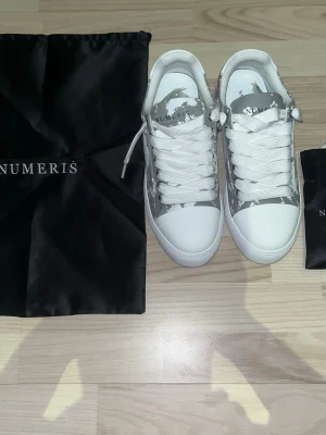 Vita och grå sneakers från Numeris - Numeris skor i ny skick, säljer på grund av fel att de för små.    Har ej kvar boxen, men extra par snören och fodral till skorna inngår.