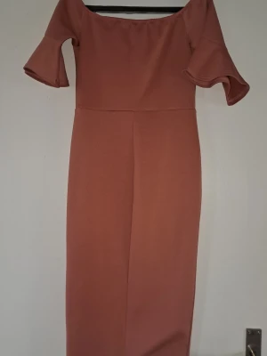 Rosa offshoulder klänning Qlub - Snygg rosa offshoulder klänning från Qlub med trumpetärmar och figurnära passform. Klänningen är lång och har en enkel, stilren design utan mönster eller extra detaljer. Perfekt för dig som vill ha en elegant look. Funkar till en 34 med