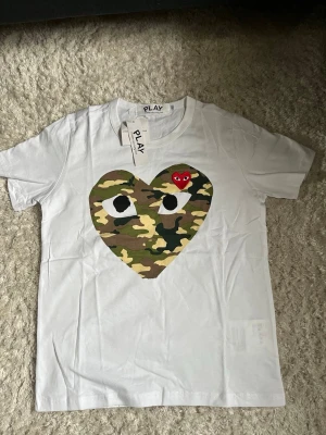  Comme des Garçons t-shirt - En vit comme des garcons t shirt i ett mycket fint skick. Storlek S. Ovanlig modell, priset går att diskutera. Skriv vid frågor eller funderingar! 