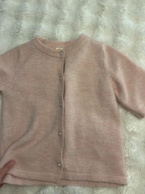 Ljusrosa kofta från Gina Tricot - Supersöt ljusrosa kofta från Gina Tricot med rund halsringning och pärlknappar framtill. Koftan är stickad i ett mjukt material och har långa ärmar samt ribbade muddar vid hals och ärmslut. Perfekt för lager på lager och en chill look. Aldrig använda och de är helt nya typ!!