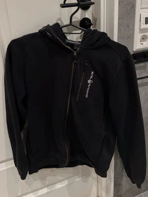 Svart hoodie från Sail Racing - Fin sail racing kofta med luva. Lite sol blekt med inte så farligt. Inga hål inga märken. 