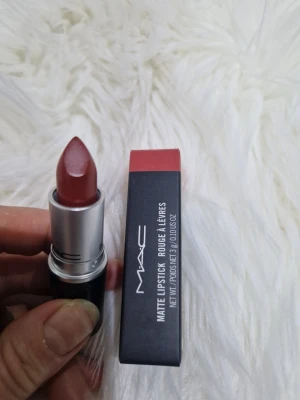 MAC Matte Lipstick Chili 602 - MAC Matte Lipstick i nyansen Chili 602. Ett matt läppstift i en varm rödbrun ton med klassisk MAC-hylsa i svart och silver. Ger en intensiv färg och sammetslen finish. Perfekt för dig som vill ha en djärv och trendig look.