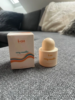 i-cos Very Vanilla Eau de Toilette - i-cos Very Vanilla Eau de Toilette är en parfym med söt vaniljdoft. Flaskan är rund och krämfärgad med matchande lock och har en modern, minimalistisk design. Förpackningen har färgglada vågmönster och tydlig text. Perfekt för dig som älskar mjuka, gourmanddofter.