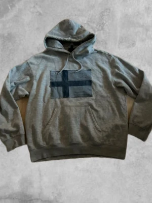 Handstiched hoodie flagga - Säljer nu en grå hoodie med en finsk flagg på! Storlek M. !GJORD SJÄLV!