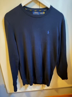 Mörkblå tröja från Polo Ralph Lauren - Klassisk mörkblå tröja från Polo Ralph Lauren i marino ull. Köpt i butik för 2200kr, Kan gå ner i pris vid snabb affär 