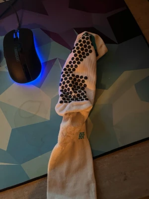 Vita strumpor från SkillSocks - Vita strumpor från SkillSocks med svarta prickar på ovansidan och turkosa detaljer. Strumporna är långa och har en sportig look, perfekta för dig som gillar att sticka ut. Tillverkade i mjuk och bekväm bomullsmix.