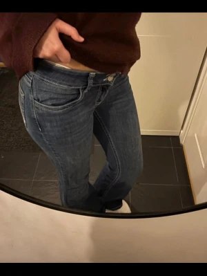 Blå bootcut jeans med kontrastsömmar - Säljer ett par blå bootcut jeans med vita kontrastsömmar från Nelly strl 36 modell short. Fattade inte att jag köpte short så om är lite korta för mig. Typ inte använt 