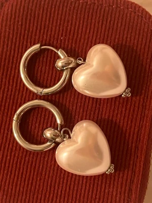 WOS örhängen - Snygga WOS örhängen i silverfärg med pärlhhörtan. Aldrig använda.