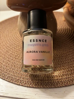 Aurora Vanille parfym från Essnce - Aurora Vanille Eau de Parfum från Essnce x Margareta Grääs. Flaskan är genomskinlig med svart kork och etikett i pastellfärger. Doften har tydliga inslag av vanilj och kommer i en stilren, modern glasflaska. Ca 70% kvar 