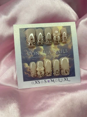 SoftLeo (M);Medium Square;Curved - Snygga handgjorda press-on naglar i beige med brunt leopardmönster och glansig finish. Några naglar har 3D-dekorationer i form av små rosetter. Formen är medium lång, och squareform för en trendig look. Dessa har en kurvad designe!