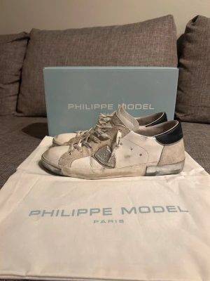 Philippe Model prsx White Silver - Snygga vita sneakers från Philippe Model med silvriga och svarta detaljer. Högkvalitativa sneakers gjorda i läder och mocka med en snygg logotyp på sidan. Köptes helt nya från Merchsweden och har använts i cirka 3 månader. Storlek 40 men passar även 40,5-41. Tveka inte på att höra av er vid eventuella frågor!