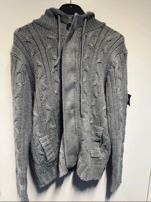 Grå stone island stickad tröja - Snygg sällsynt grå stone island stickad tröja med kabelstickat mönster och två framfickor. Bra skick. Fraktas inom 48 timmar efter köp🚛 priset kan diskuteras vid snabb affär.