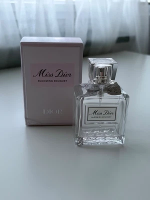 TOM FLASKA Miss Dior Blooming Bouquet  - TOM FLASKA Elegant, Miss Dior Blooming Bouquet. Flaskan är genomskinlig med silverdetaljer och en söt rosett vid halsen. Kommer i en ljusrosa kartong med klassisk Dior-design.